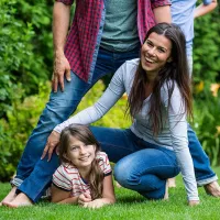 Family playing outside on green lawn