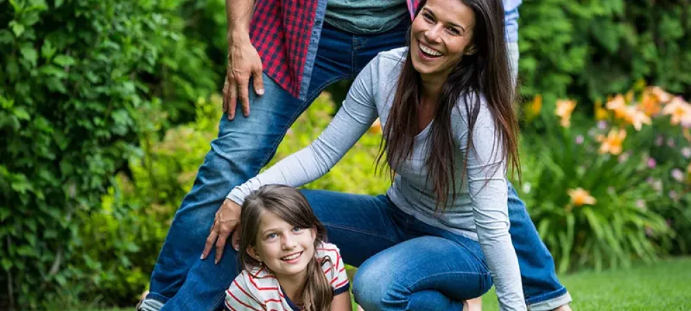 Family playing outside on green lawn